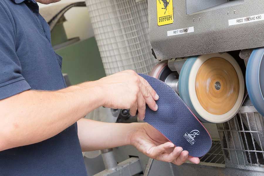 Mann bei der Arbeit mit einer SH Wittlich Industrie-Poliermaschine, während er einen Gehörschutz trägt.