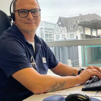 Ein Mann in einer Warnweste von SH Wittlich steht an einem Rollstuhlständer und zeigt den Daumen nach oben.